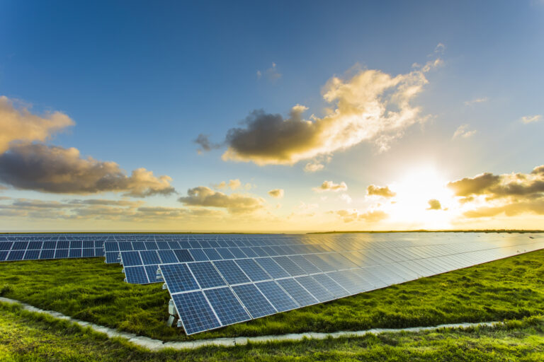 Solar panels at sunrise with cloudy sky in Normandy, France. Solar energy, modern electric power production technology, renewable energy concept